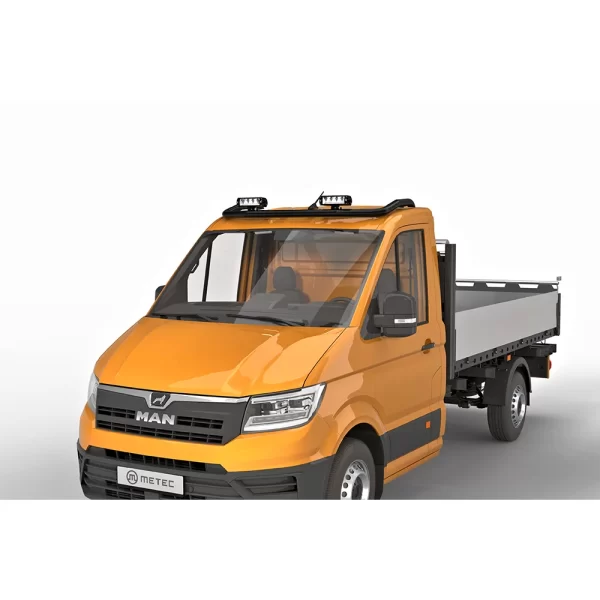 An orange MAN TGE flatbed truck is viewed from the front-left angle, showcasing a matte black roof bar mounted at the front edge of the roof. The tubular bar, with a 60mm diameter, supports three LED spotlights, evenly spaced and facing forward. The vehicle has a compact, utility-focused cabin with a dark grille, black bumper, and contrasting gray bed at the rear. The black finish of the roof bar gives it a subtle, rugged appearance, suited for work environments where additional lighting and visibility are essential.